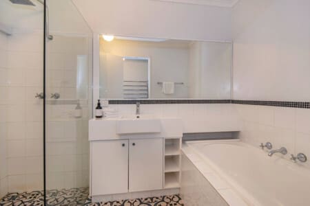 Bedroom 1 En-suite Bathroom 1 (1st Floor) with shower head and tub